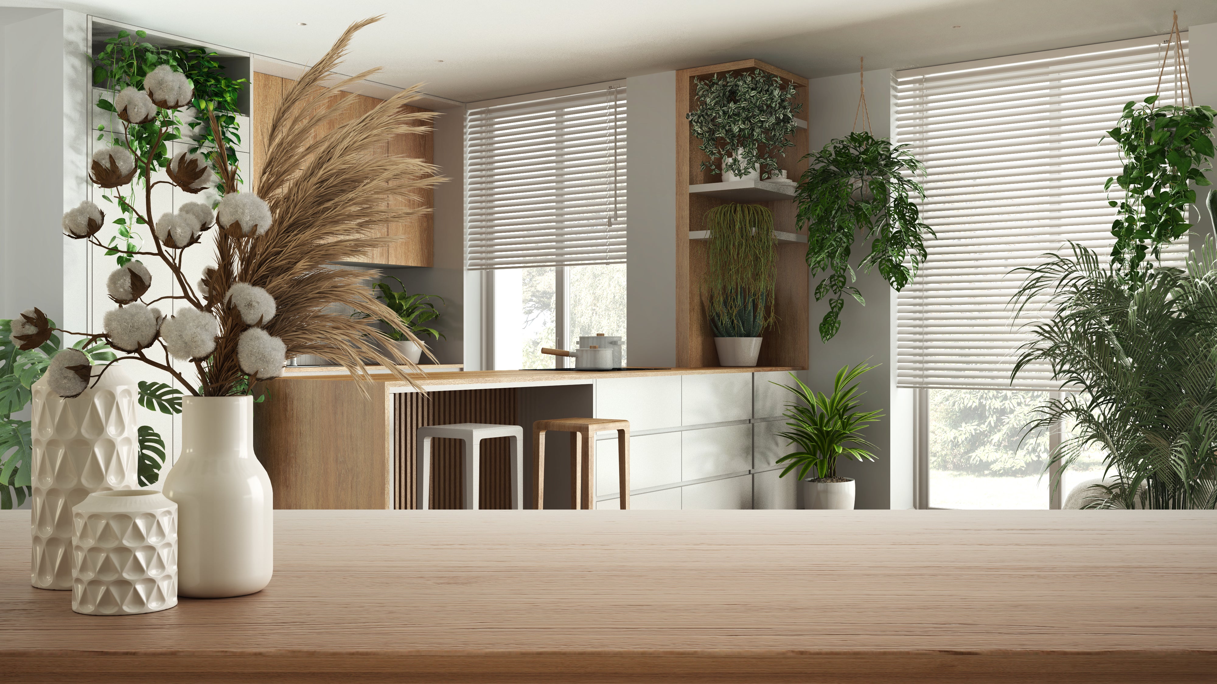 A styled tray display with two Revolution fabric swatches—one chunky neutral weave and one striped boucle—laid over a textured green fabric, with a plant, candle, and ceramic accessories adding natural accents.