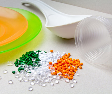 This image showcases polypropylene pellets alongside their corresponding end products, such as colorful plastic dishes and a clear cup. These pellets are fused with natural pigments to achieve vibrant, bleach-safe colors before being extruded into durable products. Similarly, Revolution Performance Fabrics utilizes the same polypropylene material to create upholstery fabrics that are bleach cleanable, maintaining consistent color and durability throughout their use.
